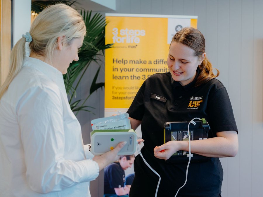 3 steps for life trainer shows woman defibrillator pads