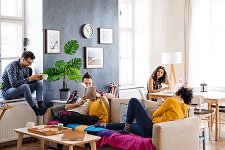 Group of young friends relaxing in their flat happily together