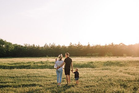 A young family in a sunlit field