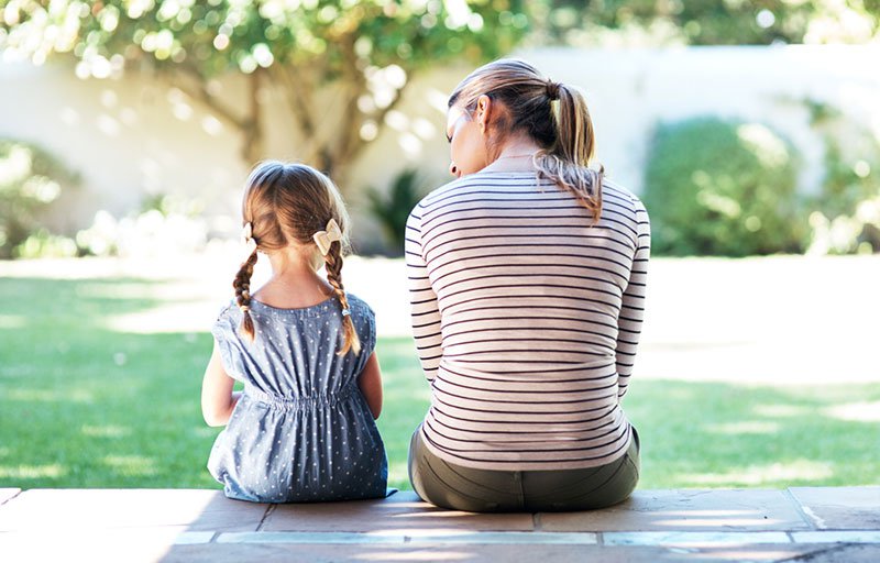 Adult and child sitting outside having a conversation