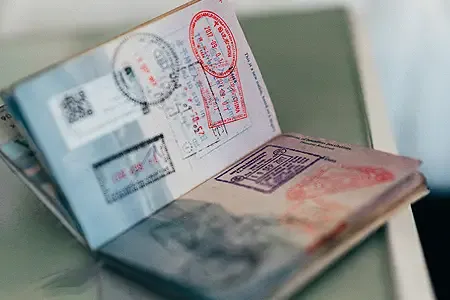 An open passport with stamps representing NZ visa extention.webp