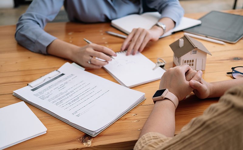 Bank manager explaining home loan documents to buyer