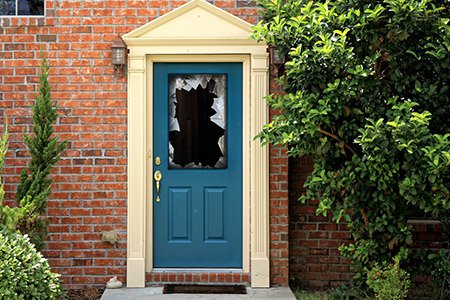 Brick home with a broken window on their door