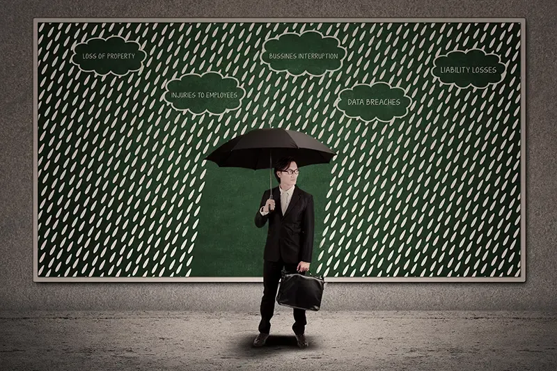 Businessman using umbrella to protect business loss