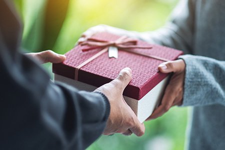 Close up of a gift being given between two people