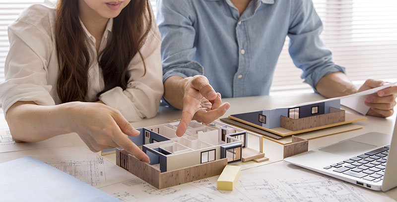 Couple playing with house model plans