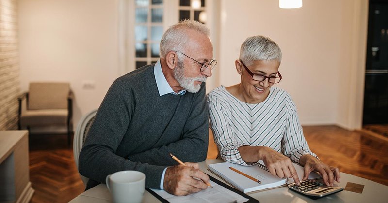 Couple sitting together working out their retirement plans