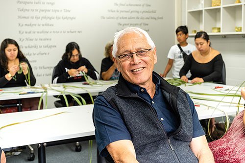 Dr David Tipene-Leach with the wakakura weaving team behind him