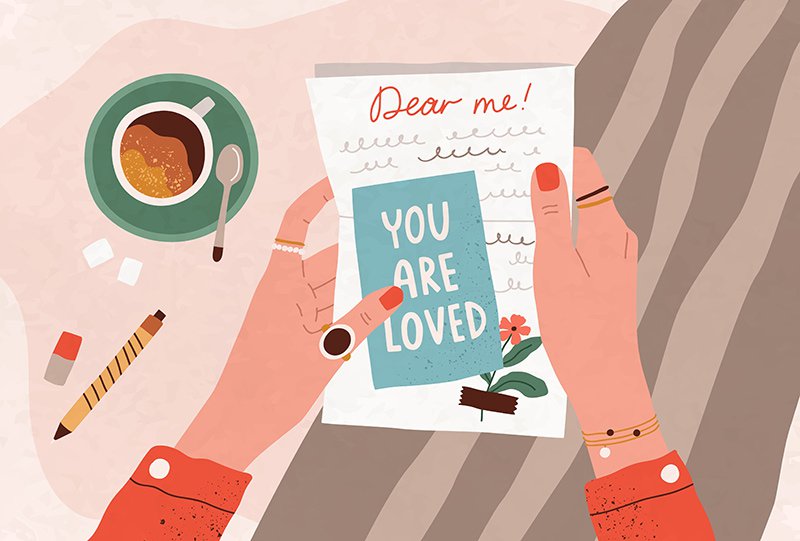 Female hands holding a handwritten letter with a message of self-love