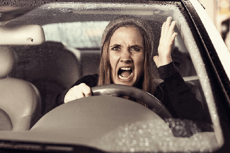 Furious-woman-driving-a-car-in-the-rain-while-cursing-at-other-traffic