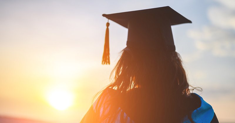 Graduate in graduation cap and gown