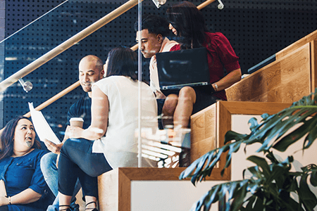 Group-of-colleagues-sitting-on-stairs-talking