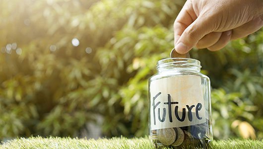 Hand-putting-money-into-jar-labelled-future