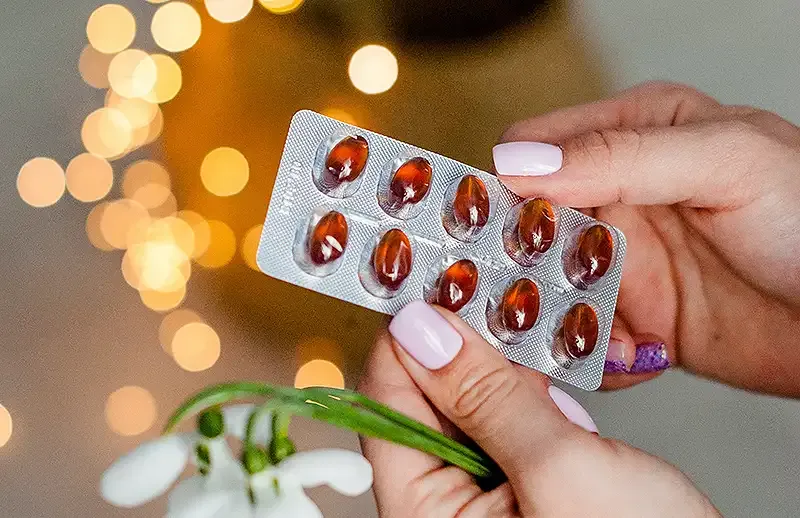 Image of someone holding vitamin pills in a packet