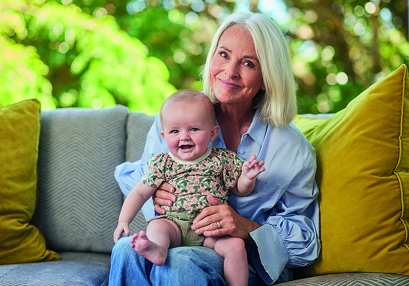 Judy Bailey sitting on a couch with her grandson