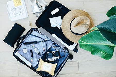 Open suitcase with clothing and valuables inside