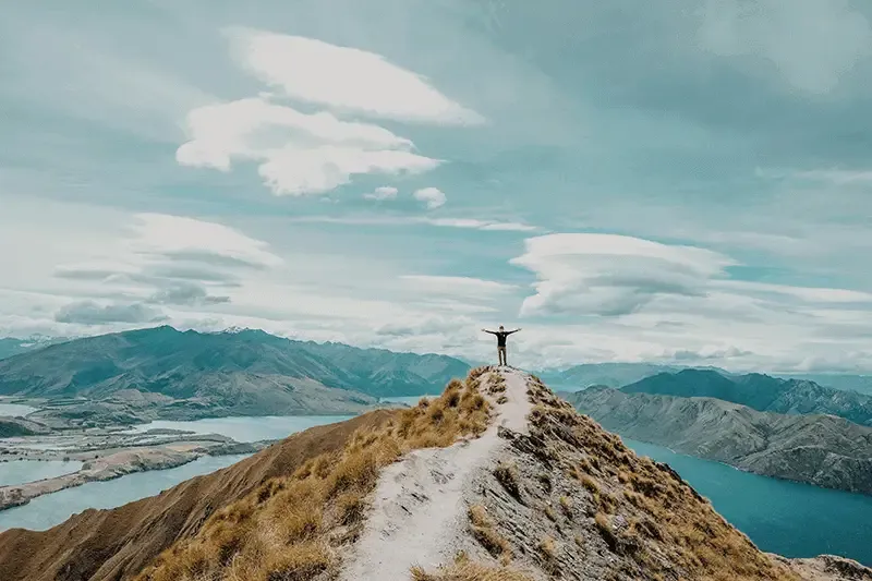 Person-standing-on-mountain-peak