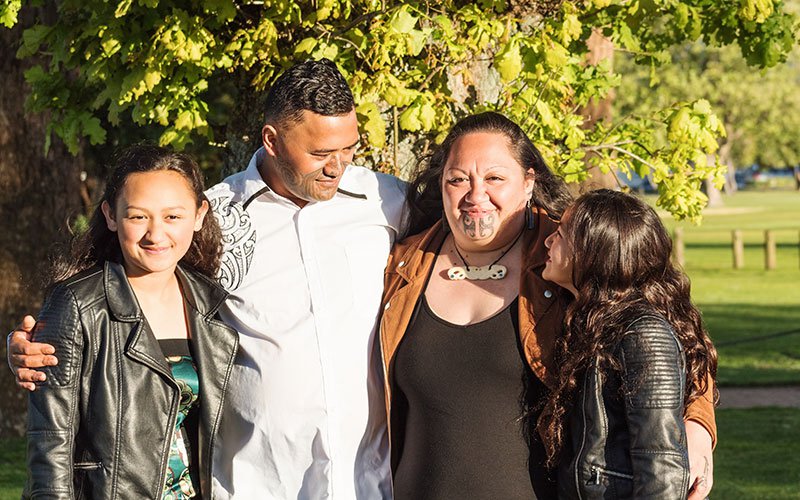 Portrait of a young Māori family outdoors