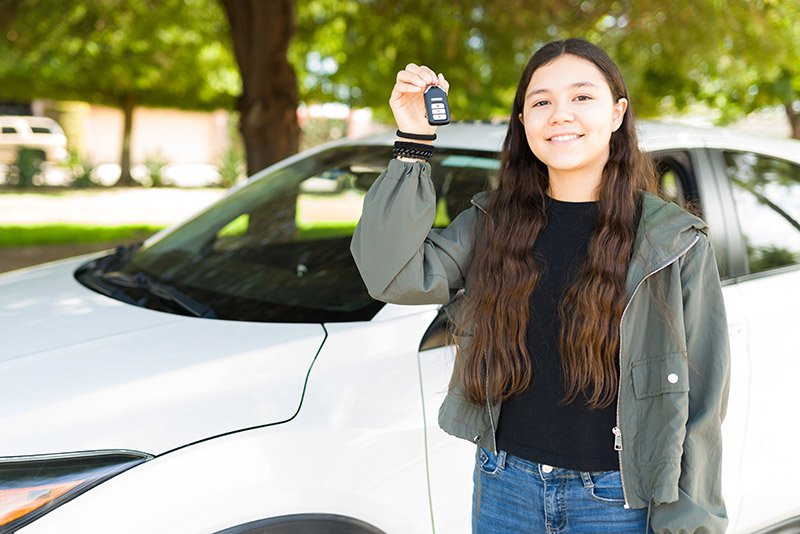 Portrait of young person holding keys to car