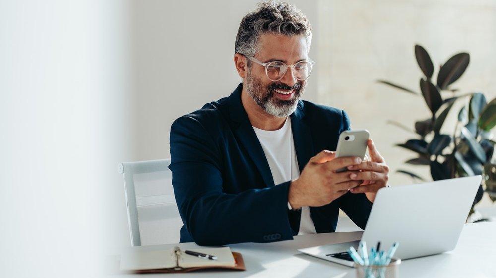 Professional man smiling on phone - rectangle