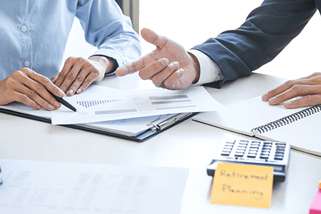 Retirement planning meeting with two men in suits looking over figures