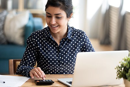 Student putting together a budget on laptop