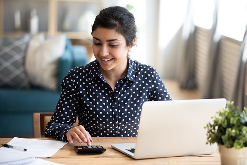 Student putting together a budget on laptop