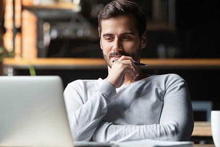 Thoughtful businessman looking at his laptop