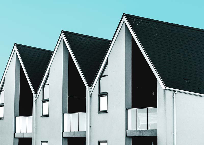 Three houses in a row under a blue sky