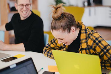 Two people at work laughing