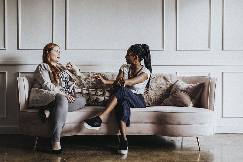 Two people having a conversation on a couch