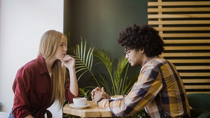 Two people having a conversation over coffee