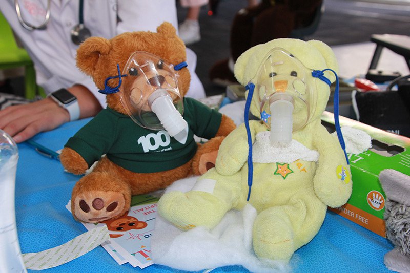 Two teddy bears at the Teddy Bear Hospital one wearing a MAS t-shirt
