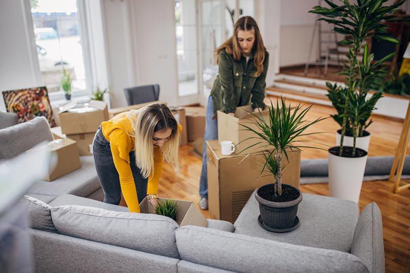 Two young women unpacking boxes in a new home