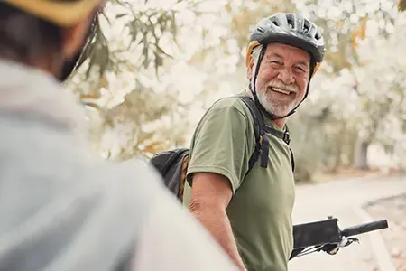 Two happy mature people riding bikes together