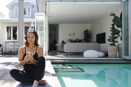 Girl on her phone sitting by the pool