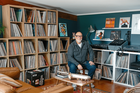Scott sitting in front of his large music collection