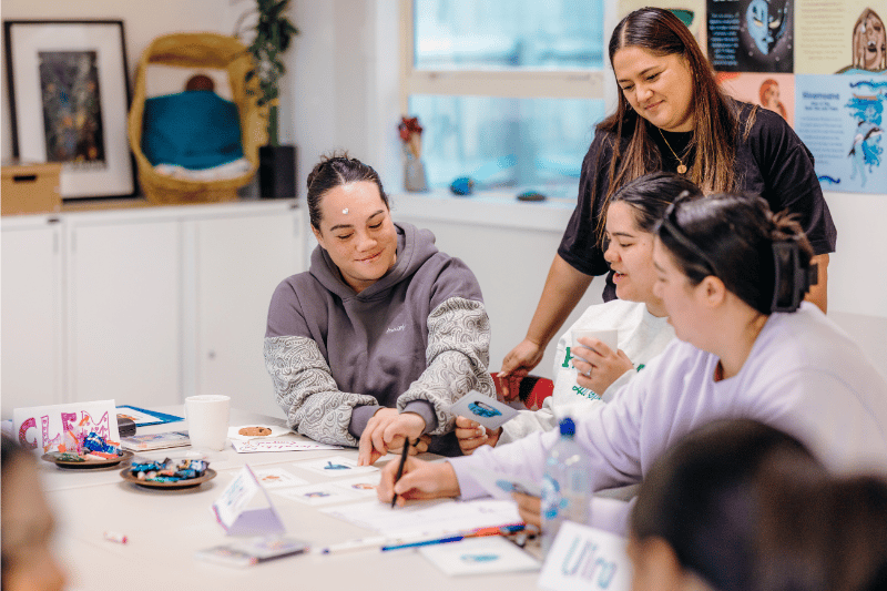 Young Māori women collaborating on some art