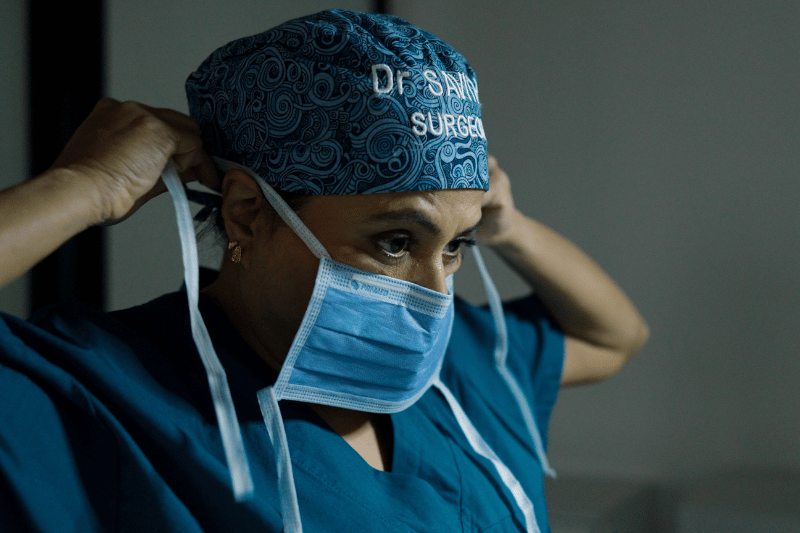 Dr Savitha Bhagvan putting her face mask on in prep for surgery