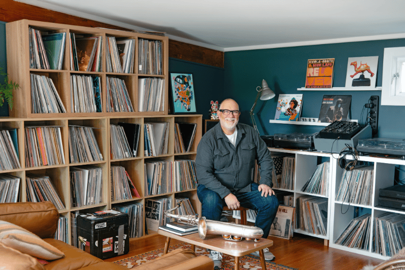 Scott sitting in front of his large music collection