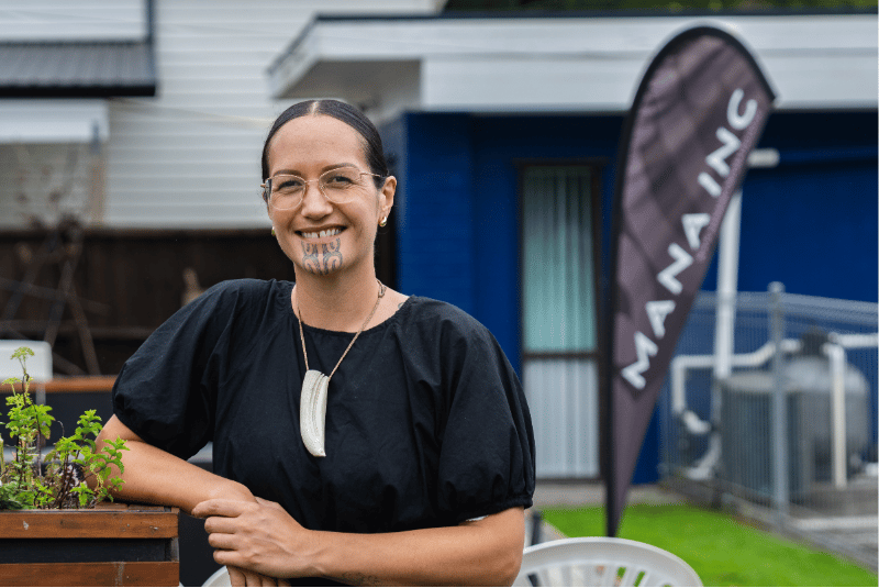 Kelly Peterson-Teariki in front of Mana Inc flag