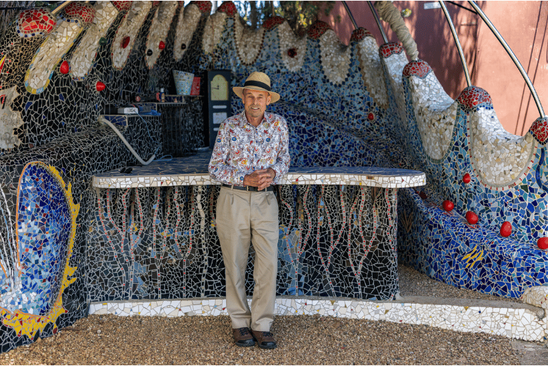 Barnett in front of his colourful mosaics