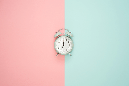 Alarm-clock-in-front-of-pink-and-blue-background