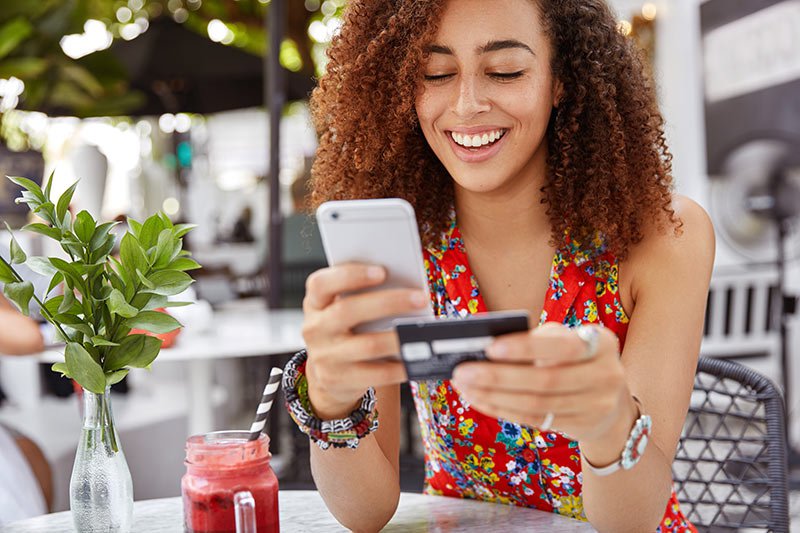 Woman holds smart phone and credit card