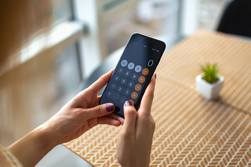 Woman using a calculator to work out spending