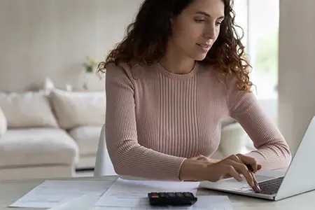 Woman working with a laptop and calculator