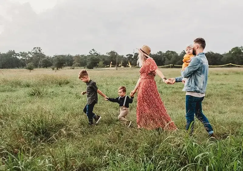Young family with three children together in a field