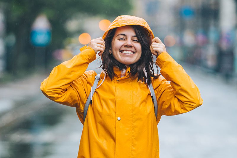 Young smiling woman in raincoat