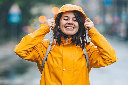 Young-smiling-woman-in-raincoat-listing