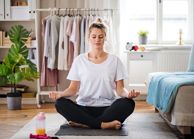 Young woman meditating indoors at home